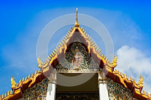 A gold color roof of buddha temple is shading by sunshine under clear blue sky