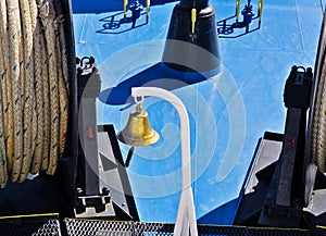 Gold colored bell on ship deck