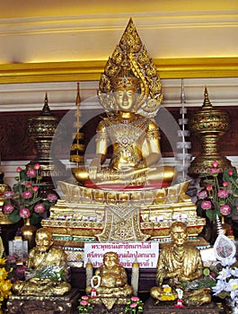 Gold-colored Buddha and monks statue in Buddhist temple