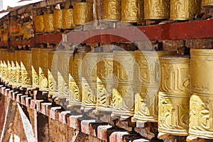 Gold colored Buddhist prayer wheels in Lhasa, Tibet