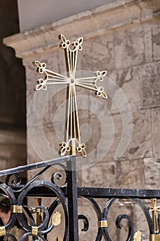 Gold colored cross sign at St. James Armenian Orthodox Cathedral during a service in Jerusalem