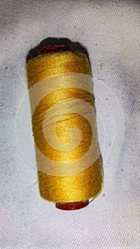 This is a gold colored fabric sewing thread.