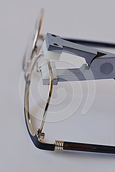 Gold coloured female eyeglass metal frame eyepiece adjusted with eyewire forming pliers