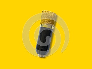 Gold condenser microphone isolated on yellow background