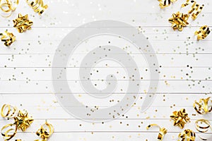 Gold confetti stars and ribbons on a White background. Copy space Flat lay. Greeting card for birthday party, Christmas Wedding