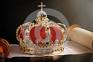 A Gold Coronation Crown with Red Velevet on a Bible on an Open Hebrew Scroll