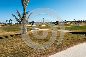 Gold course with trees and pathways under a clear blue sky in Spain