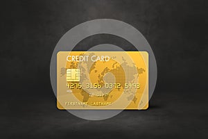 Gold credit card on a black concrete background