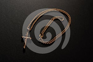 Gold cross on a chain on a black background