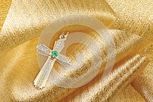 Gold cross with diamonds and emerald