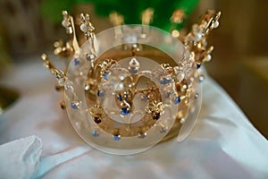 Gold crown with blue stones at the altar in the church for wedding couples traditional religious wedding ceremony