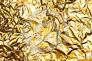 Gold crumpled foil paper texture background.