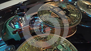 Gold crypto coin Bitcoin rotate on the Hard drive disk in macro shot. Many digital coins with green and neon light. HDD