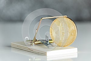 Gold cryptocurrency coin bitcoin in mousetrap on white background. Crypto currency financial trap concept.