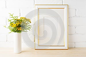 Gold decorated frame mockup yellow flowers near painted brick w