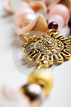 Gold detail of bijouterie with semiprecious at white background