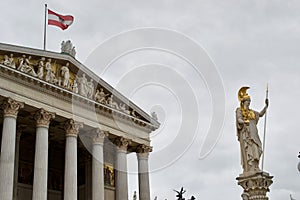 Gold detailed statue, stone pillars and flying flag outside the Austrian Parliament Building ParlamentsgebÃ¤ude or das Parlament