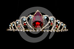 Gold diadem with red ruby stone isolated on black