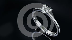 The gold diamond ring sits on a shiny black glass surface. heart shaped diamond ring design with 3d render