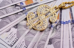 Gold Dollar Sign Necklace on a United States Dollars Banknotes