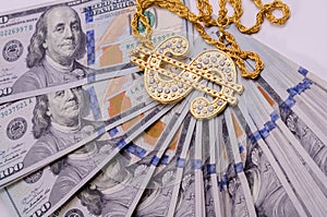 Gold Dollar Sign Necklace on a United States Dollars Banknotes