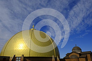 Gold Dome on Christian Church with Cross with Blue Sky and Clouds