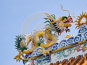 Gold Dragon on top of Chinese Temple with Blue Sky