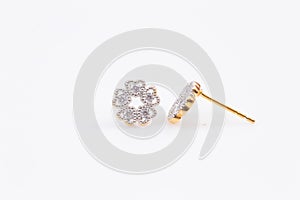 Gold earrings with diamond-shaped flowers on the white background