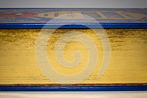 Gold edge of closed old vintage book with blue cover