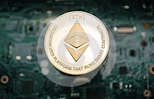 Gold etherum coin, on background of computer motherboard