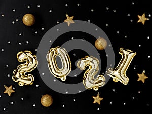 Gold  foil balloons numeral 2021, gold and silver decorations on black background. Happy New year 2021 celebration.
