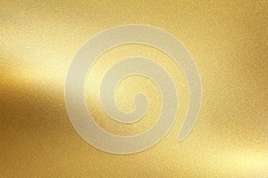 Gold foil metal wall with glowing shiny light, abstract texture background
