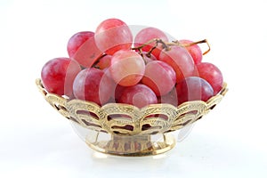 Gold fruit dish with red grape