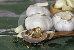 Gold garlic extract oil capsules in wooden spoon