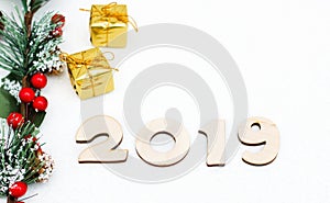 Gold gift boxes, decorative spruce branch and symbol numbers 2019 New year on white background, simple flatley Christmas card.