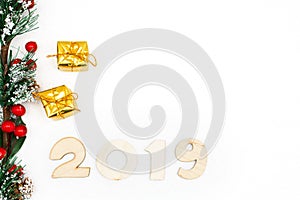Gold gift boxes, decorative spruce branch and symbol numbers 2019 New year on white background, simple flatley Christmas card.