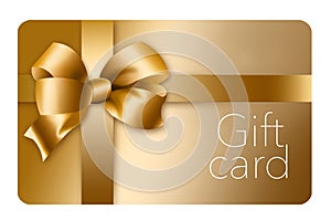 A gold gift card with a gold bow and ribbon is pictured here isolated on the background