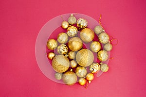 Gold glitter. Christmas balls of different sizes are collected in a bunch on a pink background. Flat lay, top view