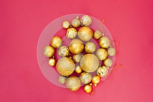 Gold glitter. Christmas balls of different sizes are collected in a bunch on a pink background. Flat lay, top view