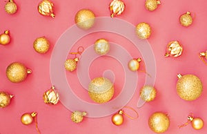 Gold glitter. Christmas balls of different sizes on a pink background pattern. Flat lay, top view.