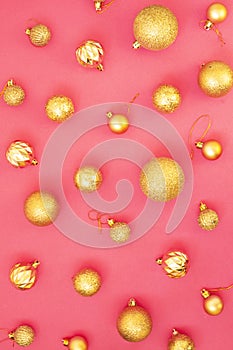 Gold glitter. Christmas balls of different sizes on a pink background pattern. Flat lay, top view.