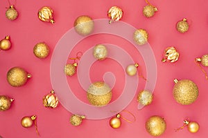 Gold glitter. Christmas balls of different sizes on a pink background pattern. Flat lay, top view.