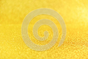 Gold glitter close up background. Sparkling yellow defocused backdrop. Glamorous golden sand grains, luxurious shimmering sequin