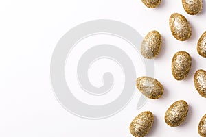 Gold glitter easter eggs on a plain white background