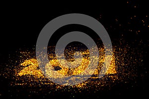 Gold glitter powder sparkling on black background