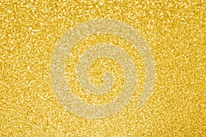 Gold glitter texture background. Yellow golden sparkle lights. Selective focus