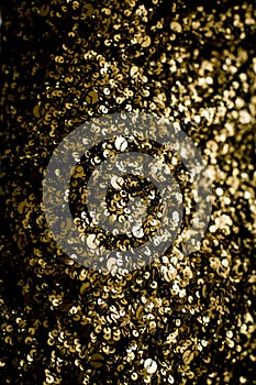 Gold glitter texture isolated on black square. Amber particles c
