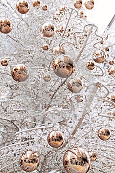 Gold glossy Christmas balls on a white glass Christmas tree.