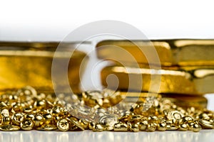 Gold granules on the background of blurred gold bars.