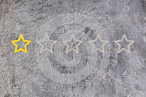 Gold, gray, silver five star shape on the gray concrete background. The best excellent business services rating customer photo